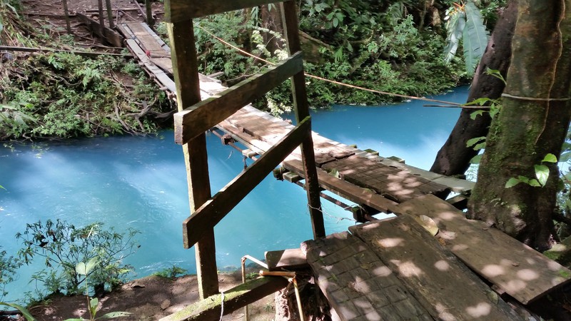 Een enge hangbrug over het prachtigste blauwe water wat je je kunt voorstellen.