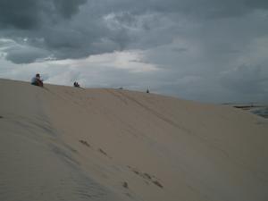 People watching the sunset from the top of the dune