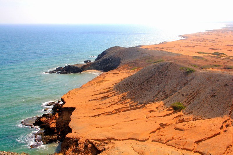Rust orange cliff plunging into the sea