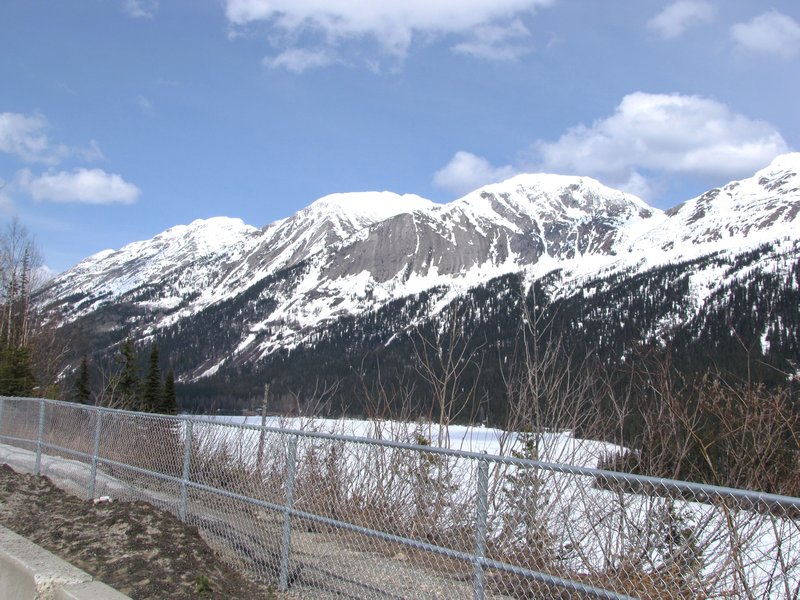 AK4 May13 part of snow-covered crest bordering highway