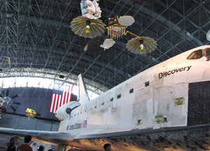 1307-55 The space shuttle, Discovery with satellites overhead