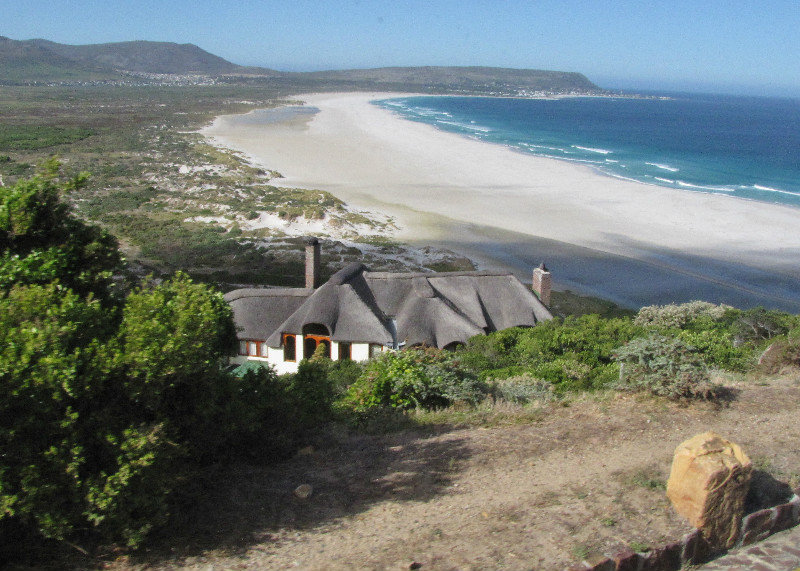 1402-25 One of several thatched houses overlooking a lovely long beach (probably Noordhoek)