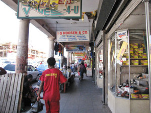 1403-285 Shops and customers on sidewalk near market