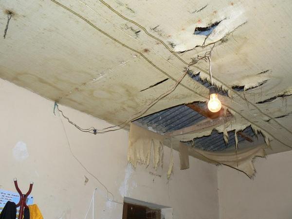 Dodgy wiring, bulb slung through rotting ceiling fabric