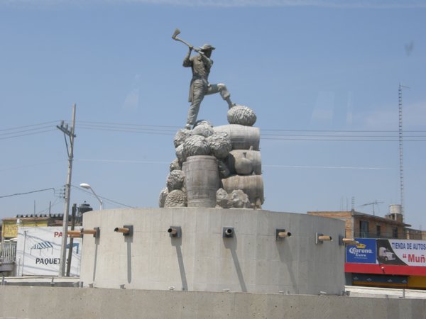 A Statue of a Man Harvesting Agave Hearts.