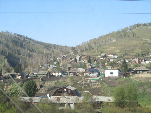 Outside the Russian train windows: wooden houses and endless forrests