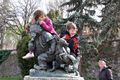 Kids playing on a small statue in a local park.