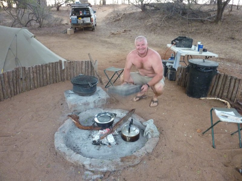 Bushman fans the fire for dinner