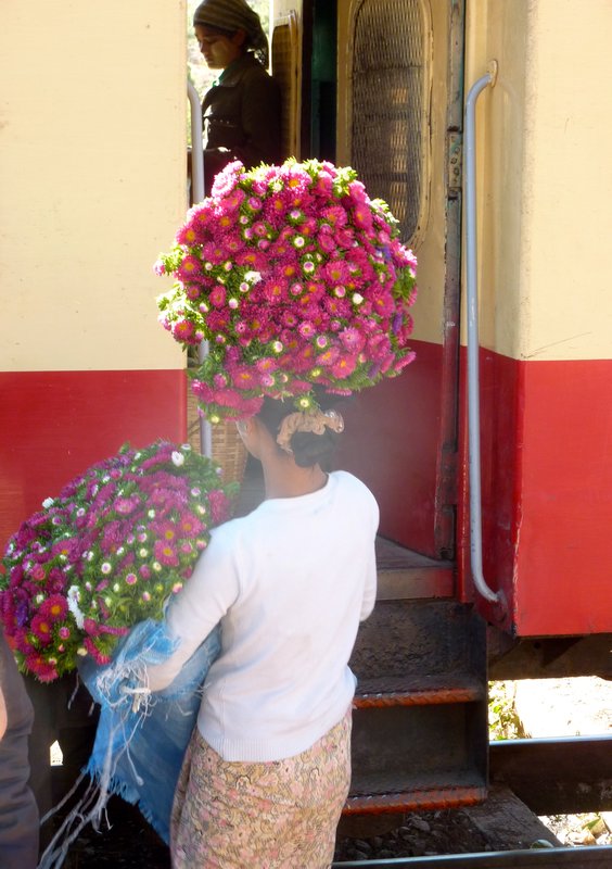 Flower seller as one of the 2 trains pulls in to the station