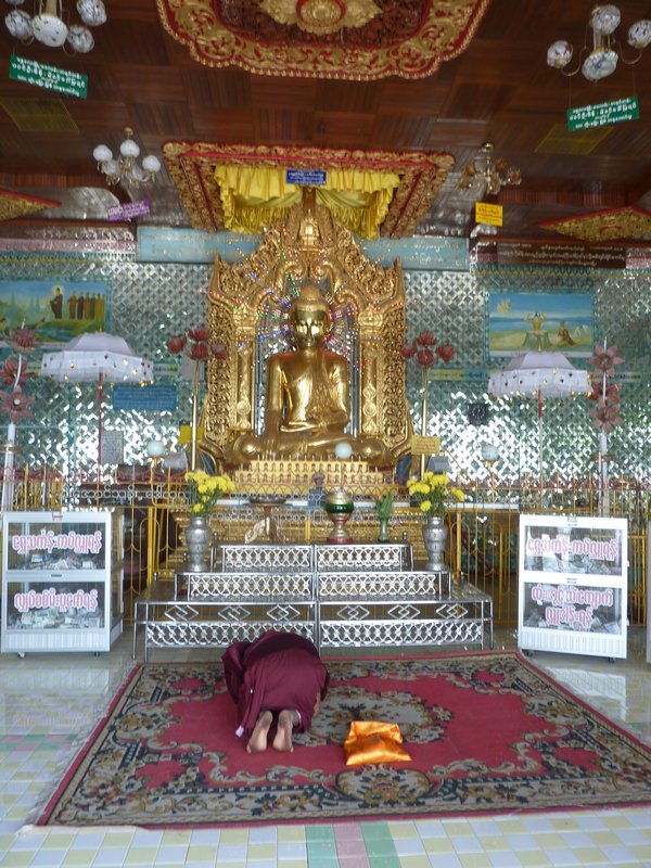 A monk prays to one of the Buddhas at Sagaing Hill