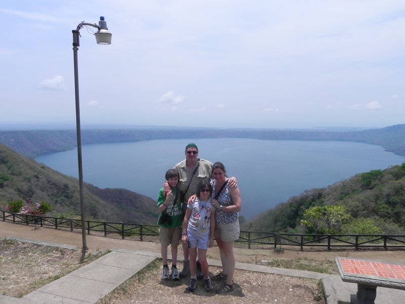 Family with volcano crater lake behind