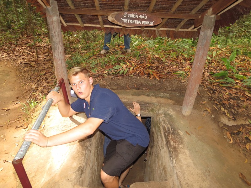 Michael entering one of the Củ Chi tunnels