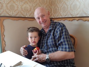 Liam giving Grandad a cuddle wile eating his nectarine