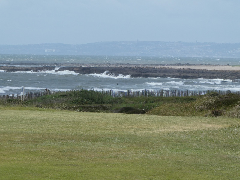Strong winds had churned up the sea and was blowing mist onto the course