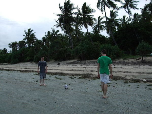 the guys playing soccer on the beach