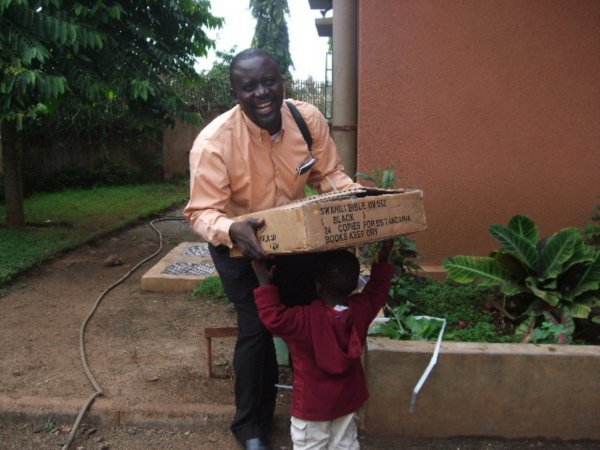 Little CJ helping carry the Swahili Bibles