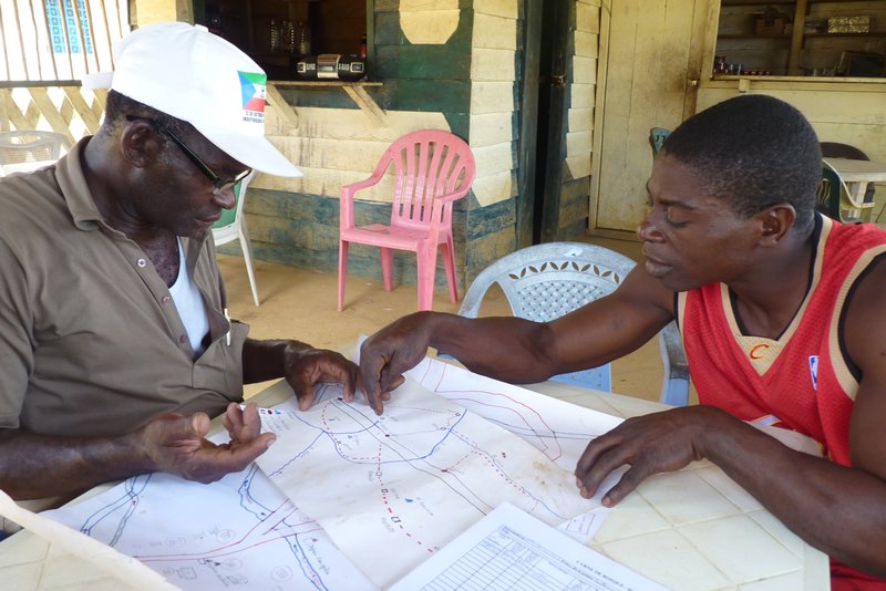 Vicente-assistant and Santos in Engong Aconibe, preparing a map of the hunting camps