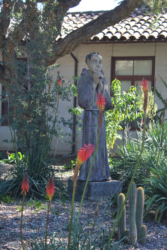 a wooden statue in the mission garden