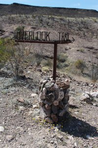 trail sign in a rock and wire pile