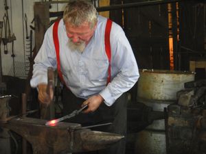 Blacksmith making a horse-shoe