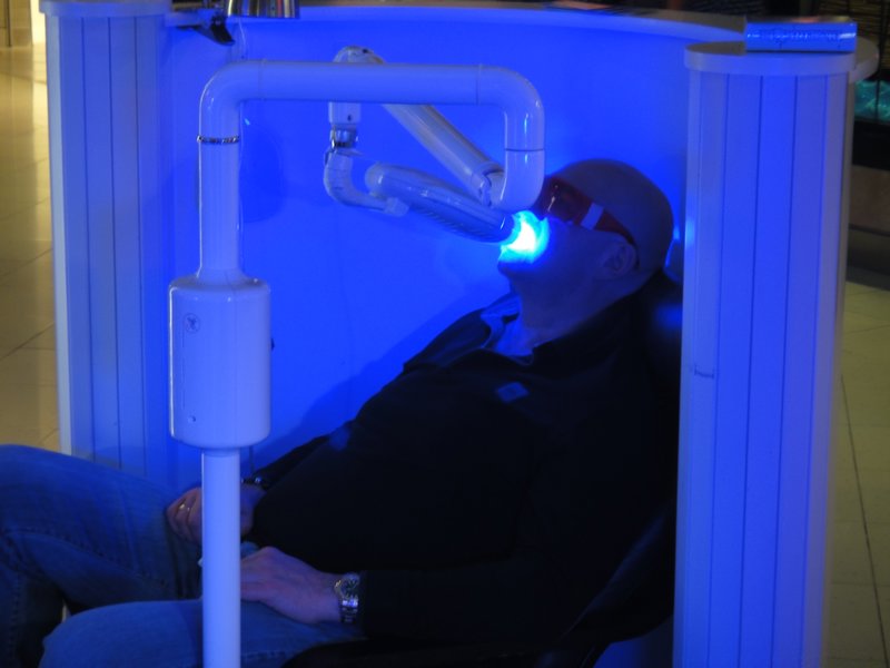 A man in a shopping mall getting his teeth whitened!
