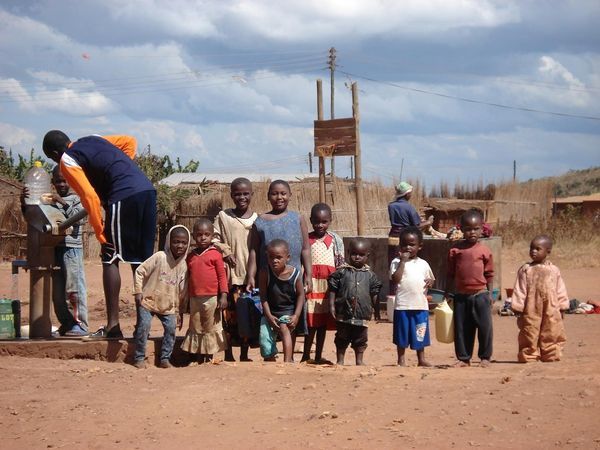 Group of kids at the water pump