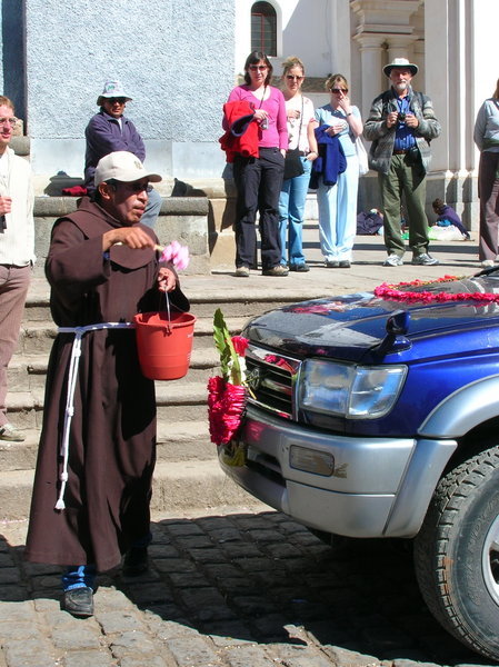 A monk blessing the automobiles