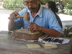 Man making Wayang puppets made of bufalloskin/man maakt Wayang poppen gemaakt van buffelhuid
