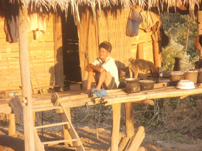 Guy outside his hut watching sunset and drying his clothes