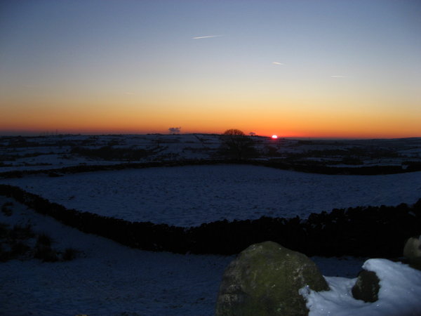 The sun sets over a wintery landscape
