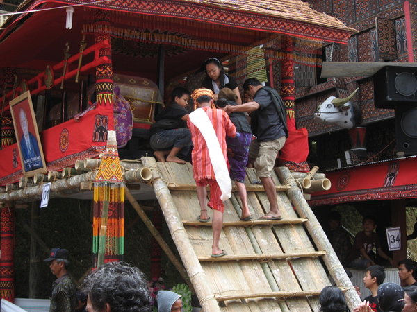 The deceased's wife being helped up to the coffin.