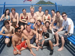 The whole PADI open water class pose for a photo on the boat