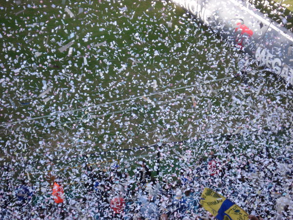 A storm of ticker tape welcomes the players on the pitch at the Boca stadium