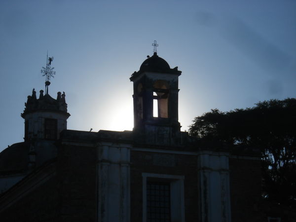 The sun sets behind the church next to the Entancia in Jesús María