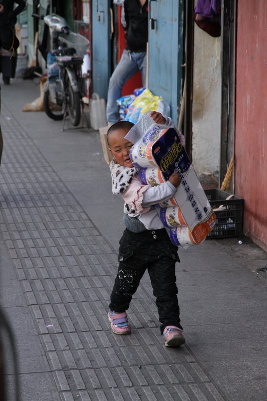 Tibetisches Kind mit tibetischem Klopapier