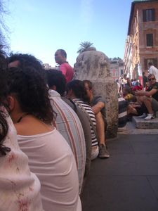 People sitting on the kerb of a pavement in Rome