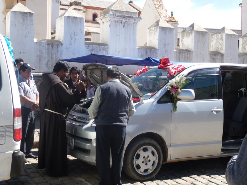 The priest blessing a van