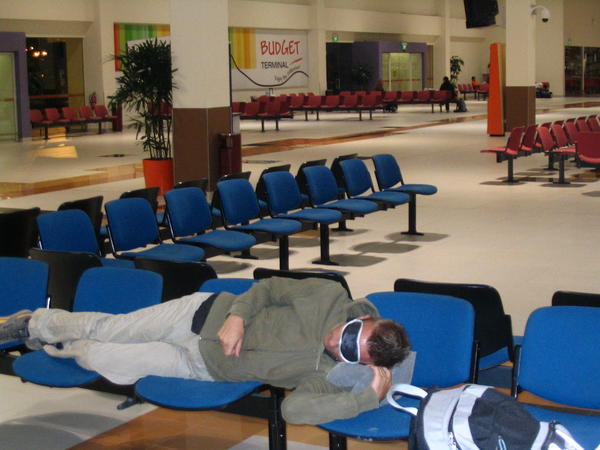 Neil sleeping in Singapore budget terminal