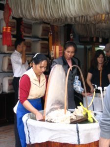 Woman pretending to make silk in the pretend silk shop in the pretend authentic chinese village