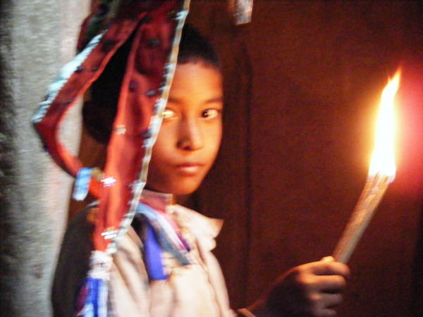 Local boy lighting incense / playing with fire in cave near Kampot