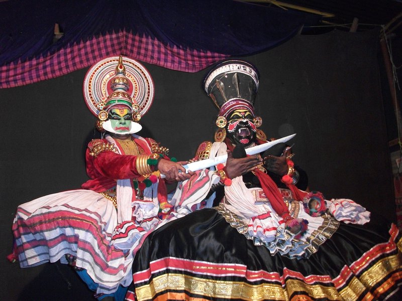 Shiva's son chopping off part of the demons breast (Kathakali dancers)