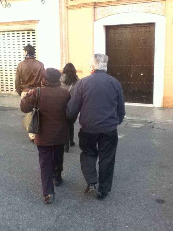 Old people who like to hold onto each other as they casually walk down the street.