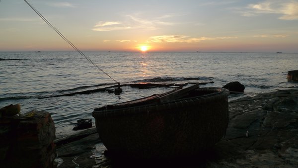 Sunset view from the patio.  The large woven bowl is actually a type of fishing boat.  Local kids love to play in the water around here.