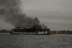 burning shipwreck sitting near Mangroves