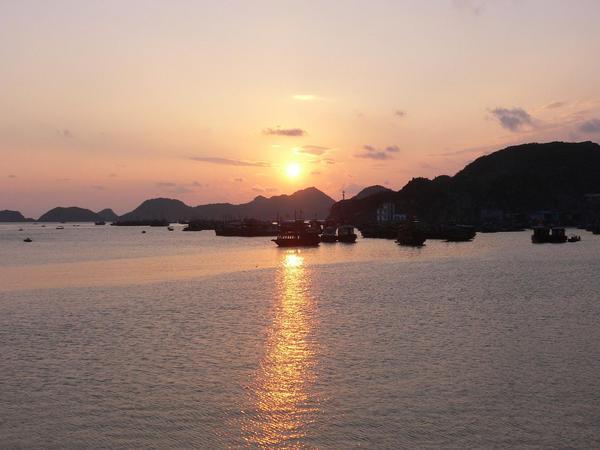 The sun setting over the islands and fishing boats from Cat Ba island