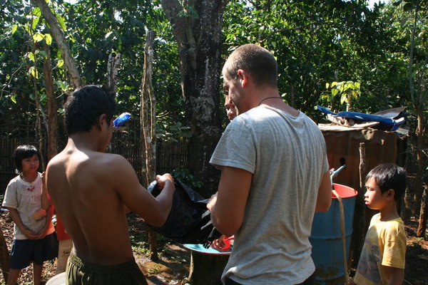 Ash explaining the Scrubba wash bag to a local Laos coffee farmer