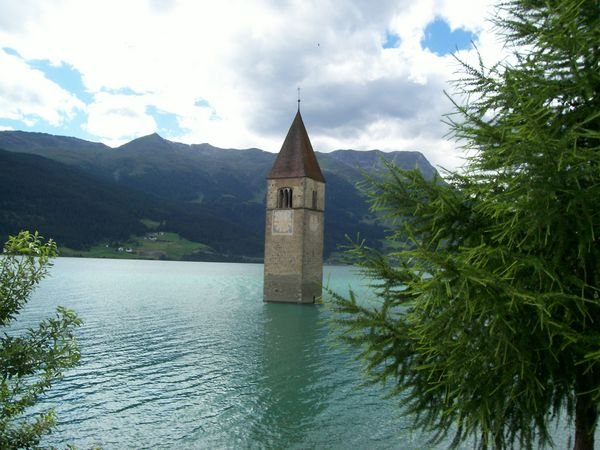 the famous Lago di Resia church tower in the water