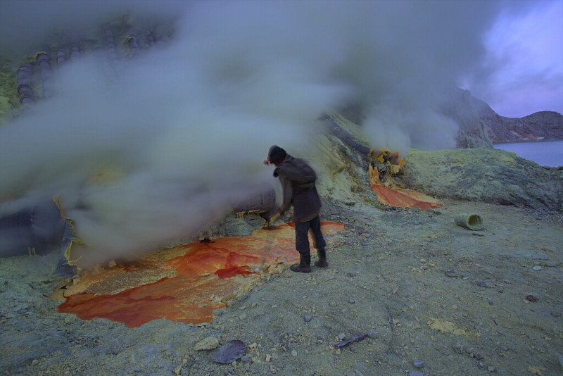 Miner breaking Sulphur up on Ijen Volcano