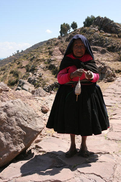 Elderly lady walking along a stone path and weaving