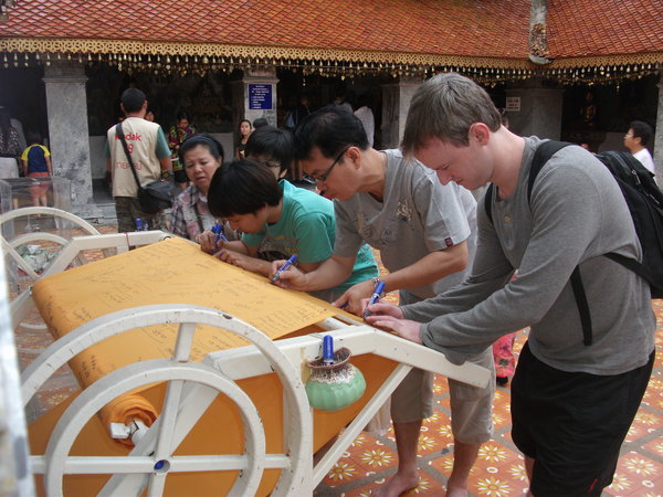 Dave signing the cloth to go around the Pagoda